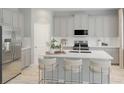 Modern kitchen featuring a large island, stainless steel appliances, and gray cabinets at 13271 Pergola Ave, Orlando, FL 32832