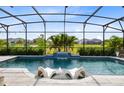 Relaxing screened pool with waterfall feature and comfortable lounge chairs, perfect for outdoor entertaining at 13807 Tybee Beach Ln, Orlando, FL 32827