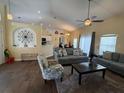 Open-concept living room with hardwood floors and comfortable seating area, perfect for entertaining at 15910 Mercott Ct, Clermont, FL 34714