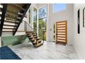 Bright foyer boasts soaring ceilings, statement staircase, and stylish wood and steel elements at 1624 E Livingston St, Orlando, FL 32803