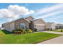A well-maintained home featuring a manicured lawn and a two-car garage on a sunny day at 1703 Daystar Dr, Haines City, FL 33844
