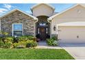 Inviting home with a stone facade, well-kept lawn, and a charming front door at 1703 Daystar Dr, Haines City, FL 33844