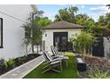 Serene backyard retreat featuring Adirondack chairs, artificial turf, and lush landscaping at 1840 Bryan Ave, Winter Park, FL 32789