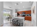 Modern kitchen with an island, stainless steel appliances, and a breakfast nook with natural light at 2263 Wyndham Palms Way, Kissimmee, FL 34747
