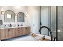 Luxury bathroom with dual vanities, a freestanding tub, and a glass-enclosed shower with herringbone tiling at 2612 Musselwhite Ave, Orlando, FL 32804