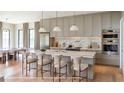 Bright kitchen featuring a marble island with seating, stainless steel appliances, and custom cabinetry at 2612 Musselwhite Ave, Orlando, FL 32804