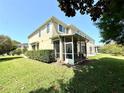 A view of the rear exterior of a townhome with a screened in porch and well-maintained grassy yard at 2656 River Landing Dr, Sanford, FL 32771