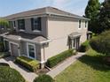 Side view of a two-story townhome showcasing manicured landscaping, a brick walkway and architectural details at 2656 River Landing Dr, Sanford, FL 32771