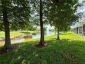 Picturesque pond view framed by trees featuring a fountain and a well maintained lawn at 2656 River Landing Dr, Sanford, FL 32771