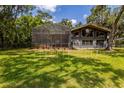 Expansive backyard featuring lush lawn, mature trees, and home with screened-in patio at 3359 Scarlet Dr, Sanford, FL 32773