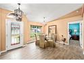 The dining room features wood-look tile floors, bright paint, modern lighting, and backyard views at 4051 Eagle Feather Dr, Orlando, FL 32829