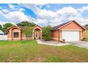 Inviting single-Gathering home featuring manicured lawn, lovely landscape, and a convenient two-car garage at 4051 Eagle Feather Dr, Orlando, FL 32829