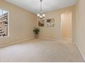 Neutral living room with light carpet, chandelier, and adjacent doorway to another room at 5062 Otters Den Trl, Sanford, FL 32771