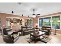 Open living room boasts tile floors, an arched doorway to the kitchen, and comfortable leather furniture at 613 Crownclover Ave, Orlando, FL 32828