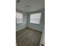 Bright, airy bedroom with hardwood floors and natural light from two windows at 73 Brooks Dr, Ormond Beach, FL 32176