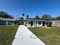 Front exterior showcasing the house, driveway, and landscaping on a sunny day at 73 Brooks Dr, Ormond Beach, FL 32176