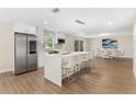 Modern kitchen featuring stainless steel appliances, a center island with bar seating, and wood-look flooring at 7470 Lake Marsha Dr, Orlando, FL 32819