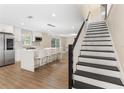 Open-concept kitchen with island seating, stainless steel appliances, and a staircase leading to the second floor at 7470 Lake Marsha Dr, Orlando, FL 32819