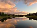 Picturesque pond reflecting a colorful sky and surrounding homes, creating a serene and inviting neighborhood atmosphere at 8405 Adalina Pl, Orlando, FL 32827