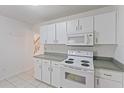 Well-equipped kitchen showcasing white appliances, tiled floor, and ample cabinet space at 8830 Sw 98Th Pl # M, Ocala, FL 34481