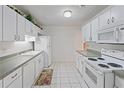 Bright kitchen featuring white appliances, ample counter space, and tiled flooring at 8830 Sw 98Th Pl # M, Ocala, FL 34481