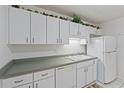 Well-lit kitchen with white cabinets, contrasting countertops, and classic hardware at 8830 Sw 98Th Pl # M, Ocala, FL 34481