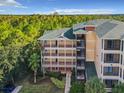 Exterior view of building with multiple levels of balconies and staircases, surrounded by trees and greenery at 9061 Treasure Trove Ln # 403, Kissimmee, FL 34747