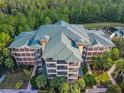 High-angle view of the building's architectural roof design, with surrounding trees and landscaping at 9061 Treasure Trove Ln # 403, Kissimmee, FL 34747