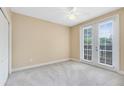 Bright bedroom with a ceiling fan, a carpet and French doors to balcony at 918 Lotus Vista Dr # 102, Altamonte Springs, FL 32714