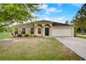 Charming single-story home with a well-manicured lawn and attached two-car garage at 927 Cambridge Ct, Kissimmee, FL 34758