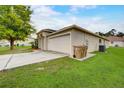 Side view of attached two-car garage with convenient trash can storage at 927 Cambridge Ct, Kissimmee, FL 34758
