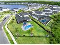 Aerial view of the spacious backyard featuring a sparkling pool, lush landscaping, and a serene lake view community at 9877 Laurel Berry Dr, Orlando, FL 32827