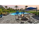 Backyard pool and patio area with lounge chairs, fire pit and outdoor seating that's perfect for relaxation and entertaining at 9877 Laurel Berry Dr, Orlando, FL 32827