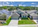 Overhead view of a well-kept home with a green lawn, an attached garage, and a neatly landscaped front yard at 9931 Cypress Knee Cir, Orlando, FL 32825