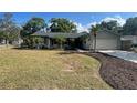 Well-maintained single-story house with lush green lawn, beautiful landscaping, and a two-car garage at 1001 Arden St, Longwood, FL 32750