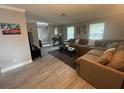 Bright living room features a comfortable sectional, plush rug, and abundant natural light from the windows at 1001 Arden St, Longwood, FL 32750