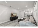 Bright, open-concept living area with modern flooring and a seamless transition to the kitchen at 13 Fanfair Ave, Orlando, FL 32811