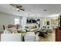 Spacious living room featuring tile flooring, ceiling fan, and large sofas at 1300 Island Green St, Davenport, FL 33896