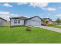 Well maintained one-story house featuring a lovely front lawn and attached garage at 1312 Axel Graeson Ave, Kissimmee, FL 34744