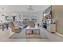 Bright living room featuring a large sectional sofa, stylish lighting, and neutral decor at 1312 Axel Graeson Ave, Kissimmee, FL 34744