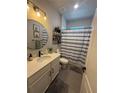 Well-lit bathroom featuring a decorative shower curtain, plants, and an attractive vanity mirror at 13299 Serene Valley Dr, Clermont, FL 34711
