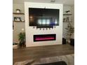 Living room featuring a large-screen television, fireplace, and floating shelves at 13299 Serene Valley Dr, Clermont, FL 34711