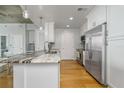 Modern kitchen featuring stainless steel appliances, white cabinetry, and a marble countertop island at 155 S Court Ave # 1305, Orlando, FL 32801