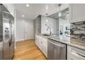 Well-lit kitchen with stainless steel appliances, granite countertops, and wood flooring at 155 S Court Ave # 1305, Orlando, FL 32801
