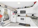 Functional kitchen featuring white cabinets, tile floors and countertops, and essential appliances at 1612 Sandy Point Sq # 56, Orlando, FL 32807