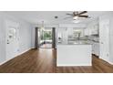 Dining area with wood floors that connects to a bright kitchen and screened patio at 17 W Nightingale St, Apopka, FL 32712