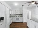 Bright, white kitchen with updated appliances, granite counters, and wood-look flooring at 17 W Nightingale St, Apopka, FL 32712