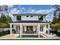 Beautiful backyard featuring a swimming pool, outdoor dining area, patio furniture, and lush greenery at 2422 Musselwhite Ave, Orlando, FL 32804