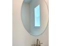 Modern bathroom showcasing a round mirror, bright lighting, and a brushed metal faucet at 4185 Sagefield Dr, St Cloud, FL 34773