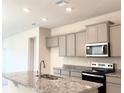 Bright kitchen with gray cabinets, stainless steel appliances, and granite countertops on the island at 4185 Sagefield Dr, St Cloud, FL 34773